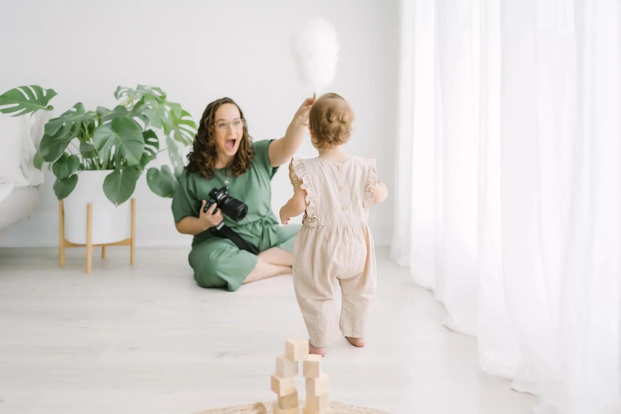 photographer playing with kid for family photography in Hamilton​ photo studio
