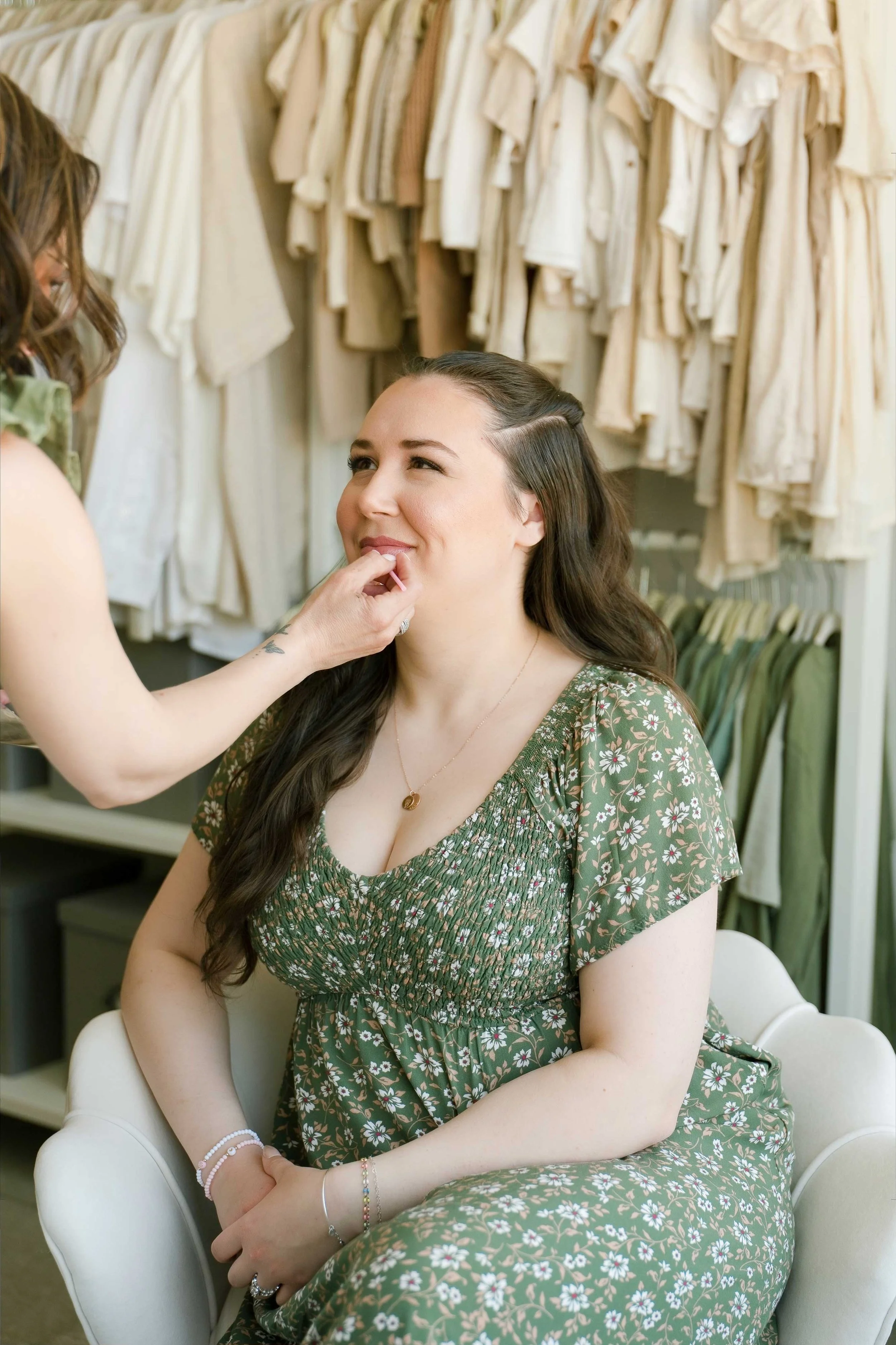 Hair and makeup artist applying lipstick to client before newborn photography session in Grimsby