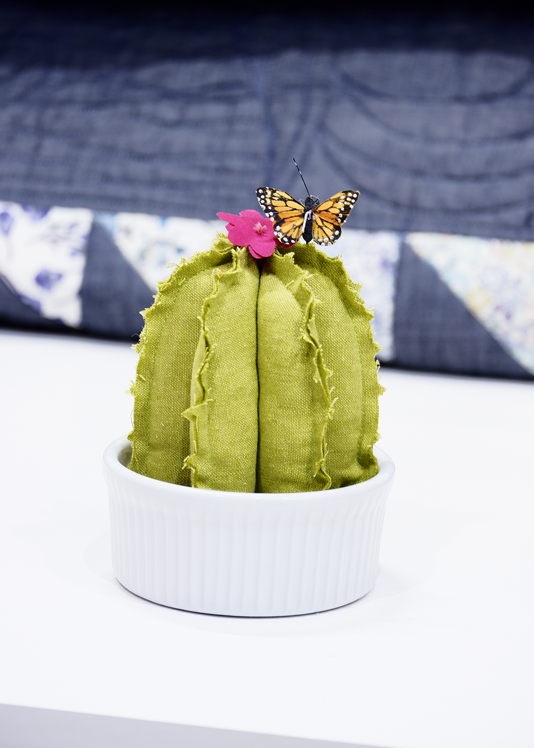 Finally place your fiber cactus in a planter, dish or on a piece of wood and remember not to water it. I picked up a little butterfly in the floral section of a craft store to add a little zest to it. Isn’t it fun? You can make them out of so many materials - felt, foam, cotton, velvet and so many more! I chose the linen for its loose weave, liking how the little frays resemble the fuzziness you sometimes see on them.