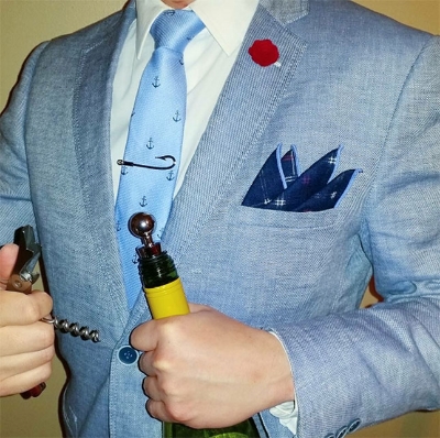 The aquatic colors of this month's tie and pocket square pair well with a blue linen blazer and the fish hook tie bar from March’s Fulton Box .