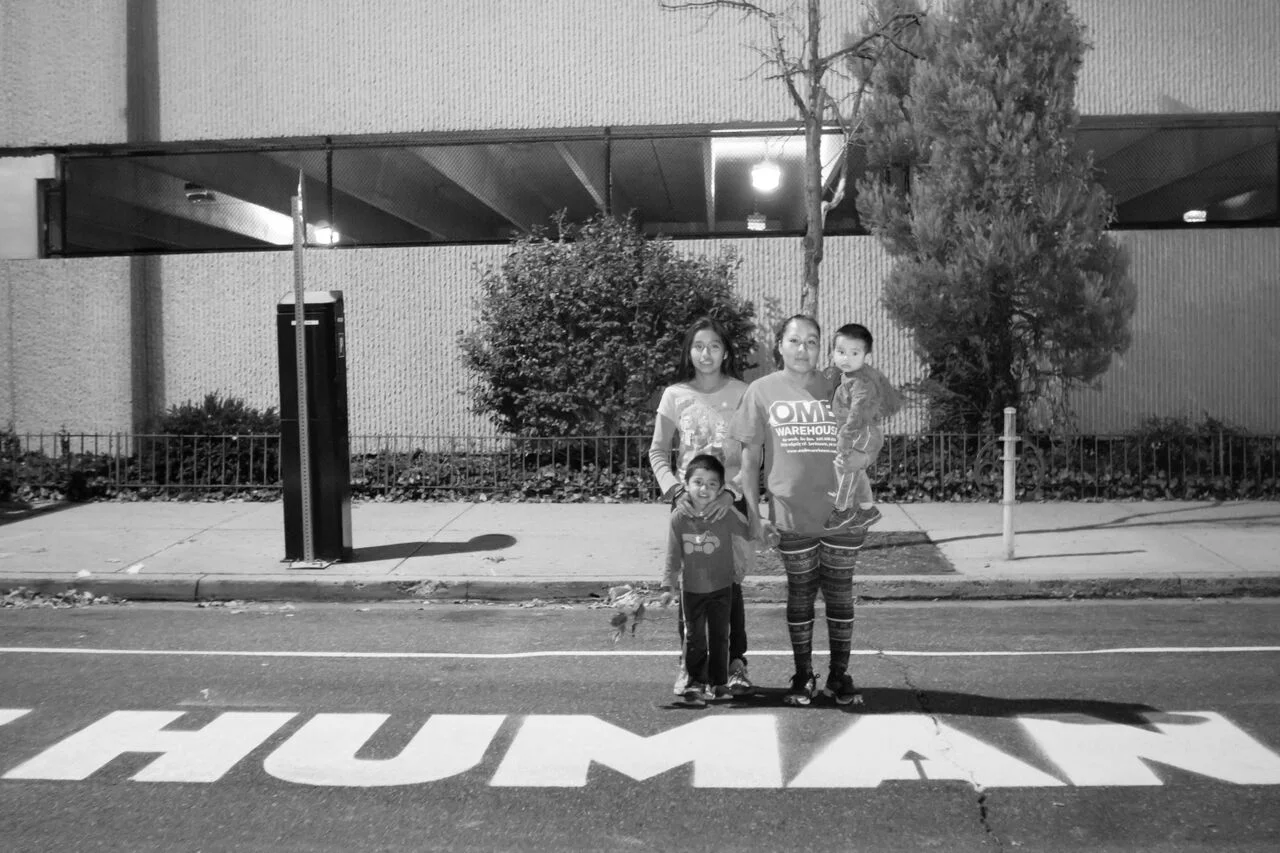 Photo Credit Jose Mazariegos. Alma and her children stand in front of Ortiz's art installation the ICE building. Alma who fought against the deportation of her husband, Javier.