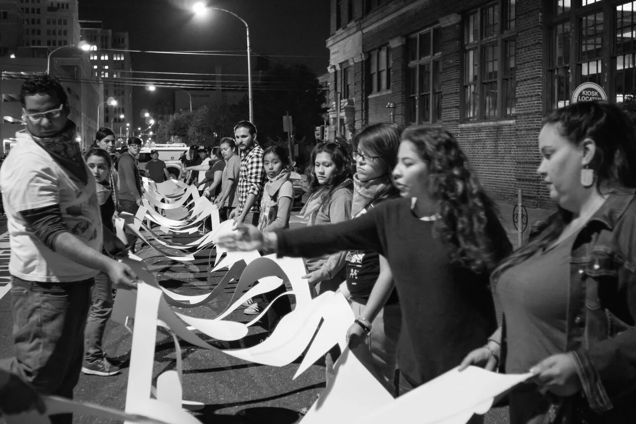 Photo Credit Jose Mazariegos. Ortiz installs the words of Ana, a mother formerly detained the Berks Detention Center. Joining her are undocumented families/ community members from Juntos.