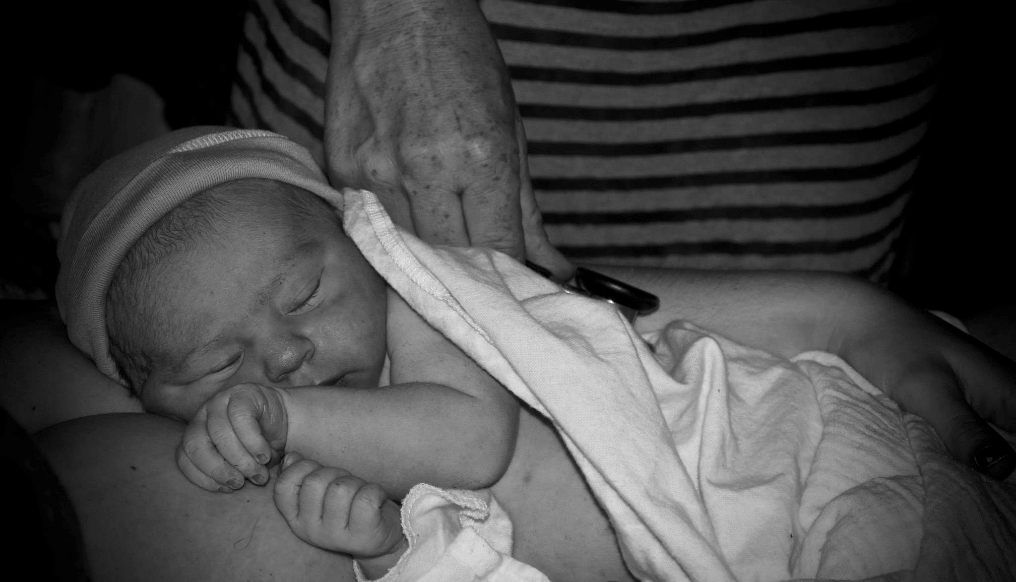 Midwife Annique Sampson, CPM, LM, NHCM listens to a baby boy during his newborn examine at a birth in Vermont, late summer 2015. 