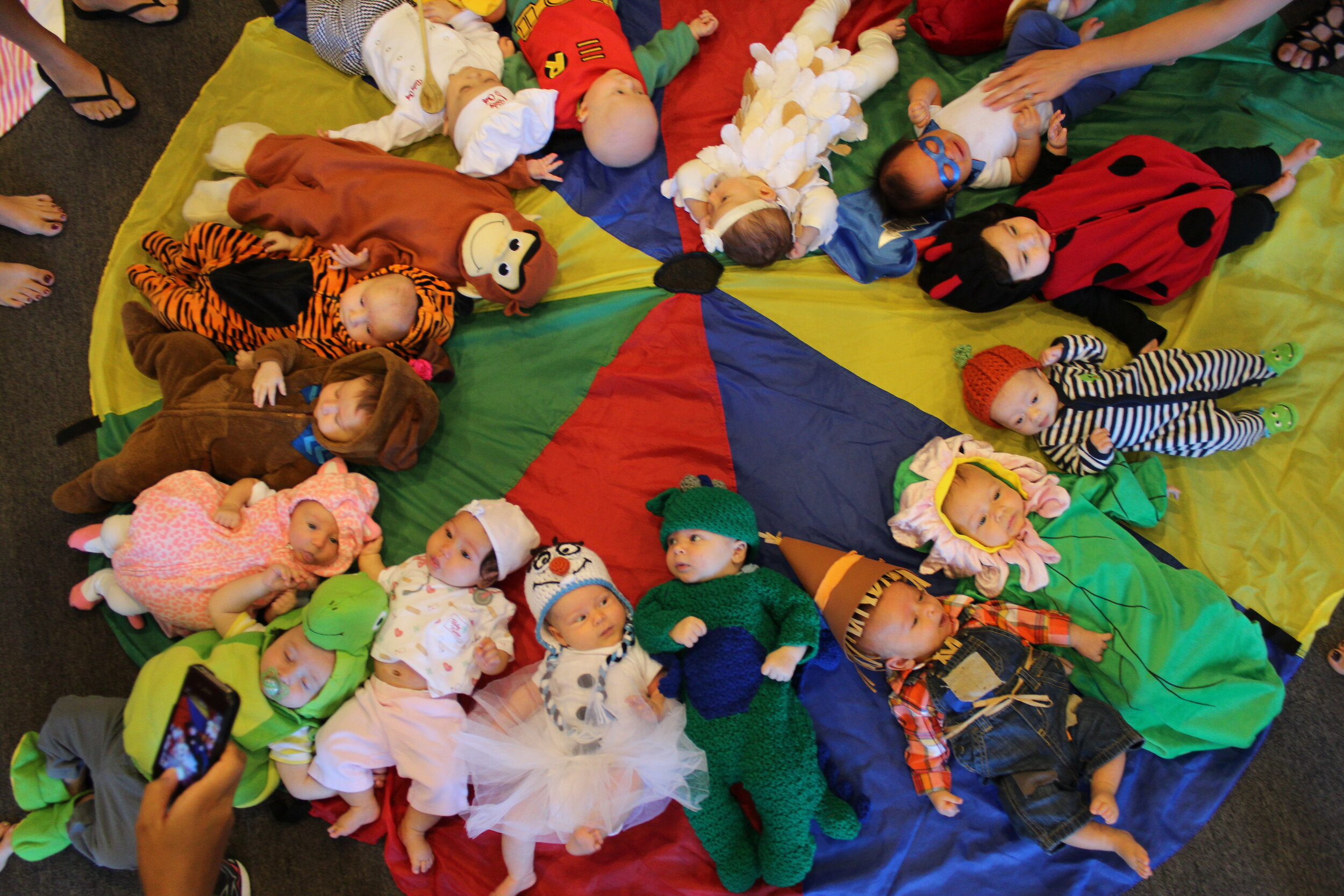 At a Mommy and Me class in Los Angeles, California, babies lay in a circle dressed in fun, colorful costumes.