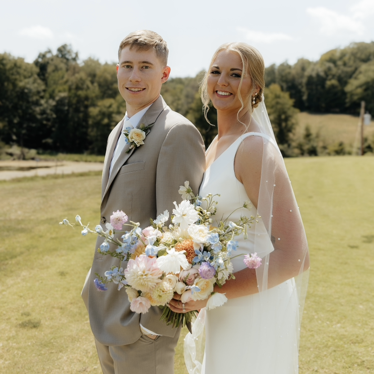 couple with pastel summer flower bouquet and boutonniere.PNG
