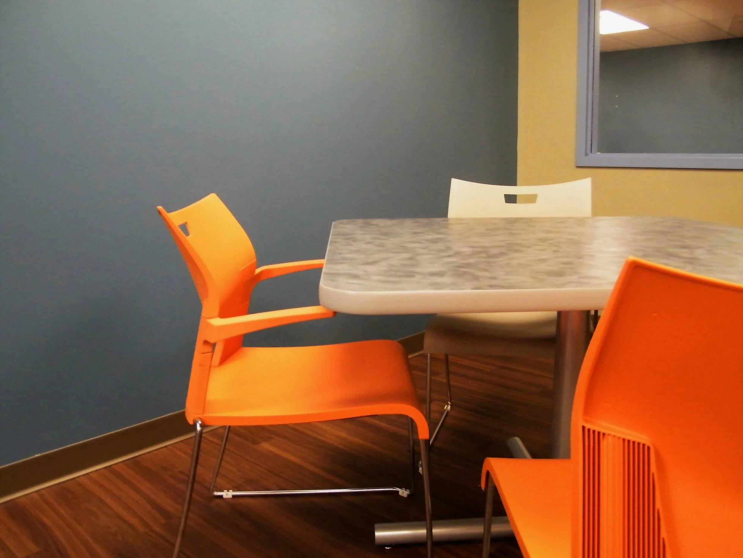 PVC Table with Laminate Top on Cross Base with Duet Chairs with Arms and Without Arms in Orange and Grey