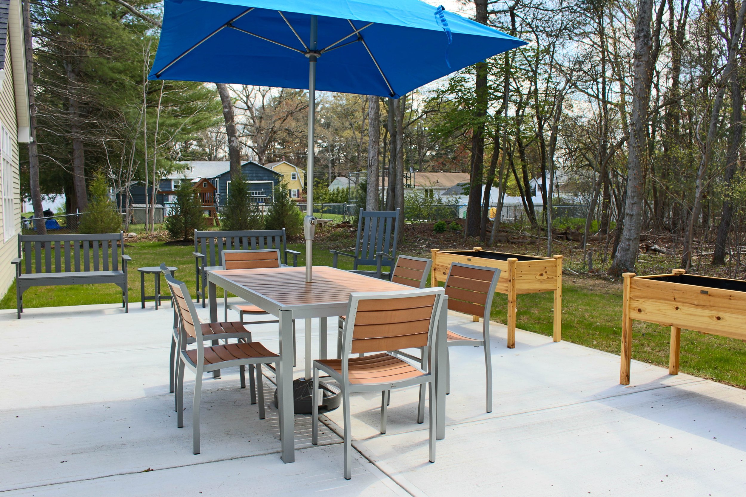 Charles River Center_Brockton_outdoor patio_Montaul 35x71 table w umbrellaand planter tables.jpg