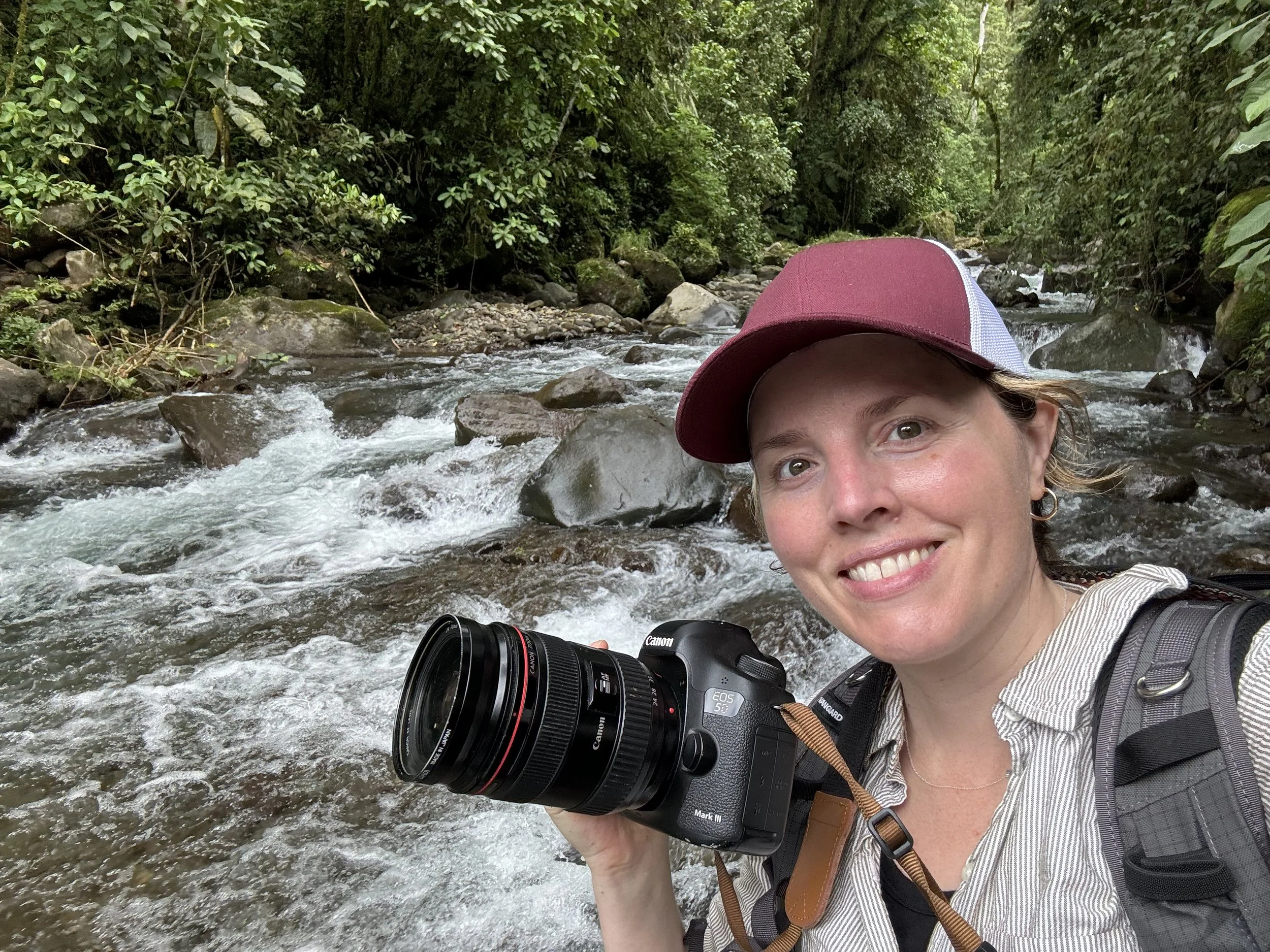 Meghan McMackin with camera by jungle river in Costa Rica