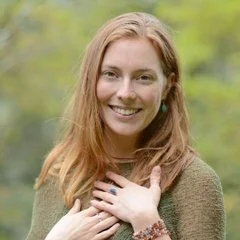 Smiling woman with red hair in outdoor setting