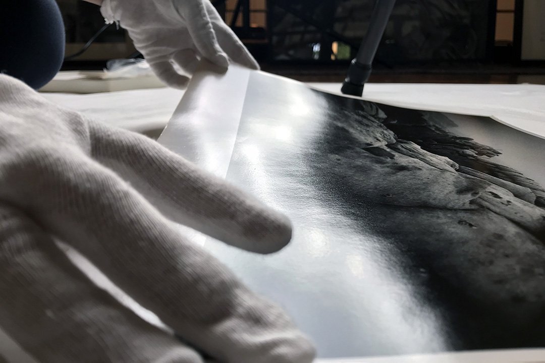 Closeup of Jamie's fingers adjusting a fine art print
