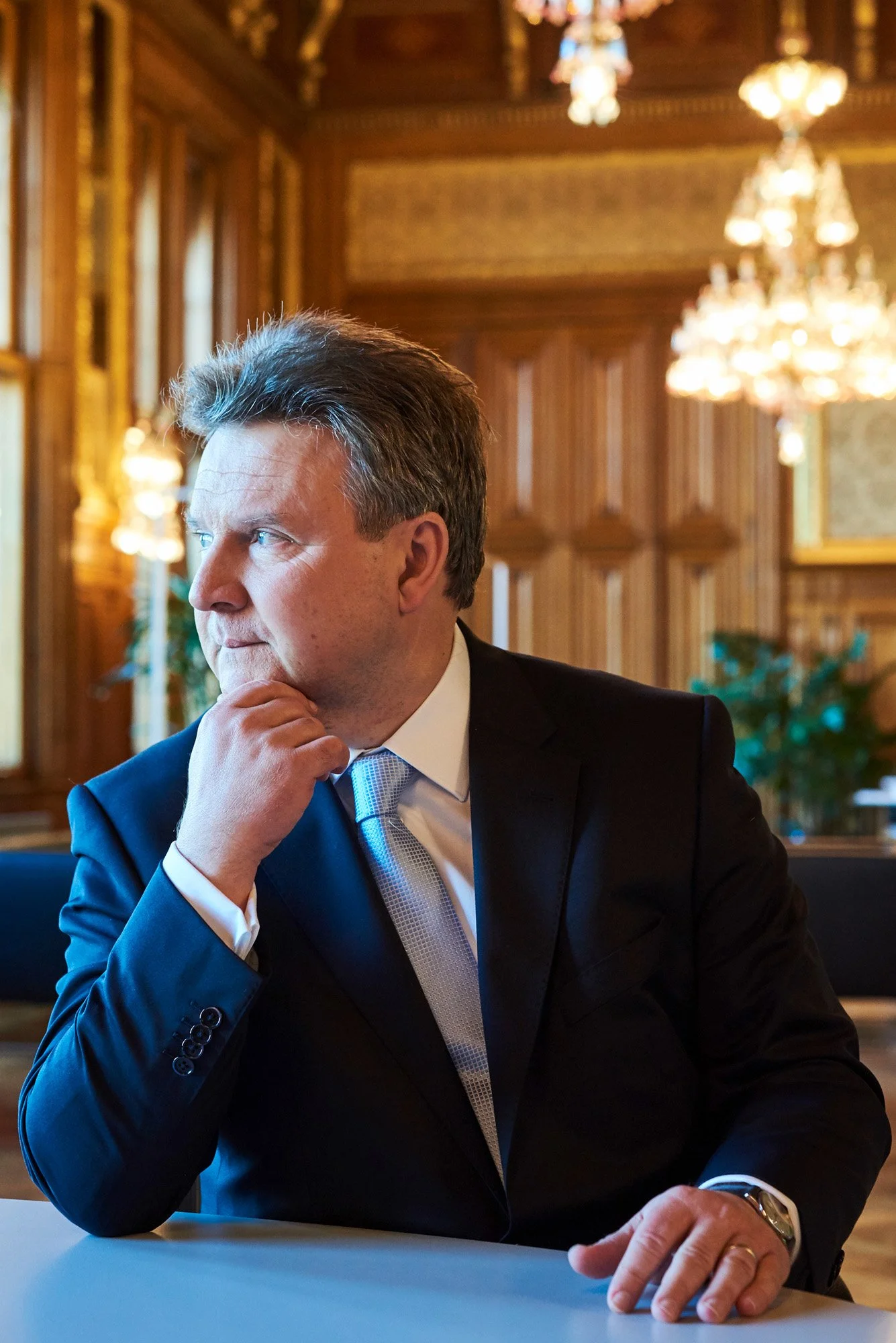 Wiens Bürgermeister Dr. Ludwig sitz in deinem Büro an einem Besprechungstisch und sieht zum Fenster hinaus.