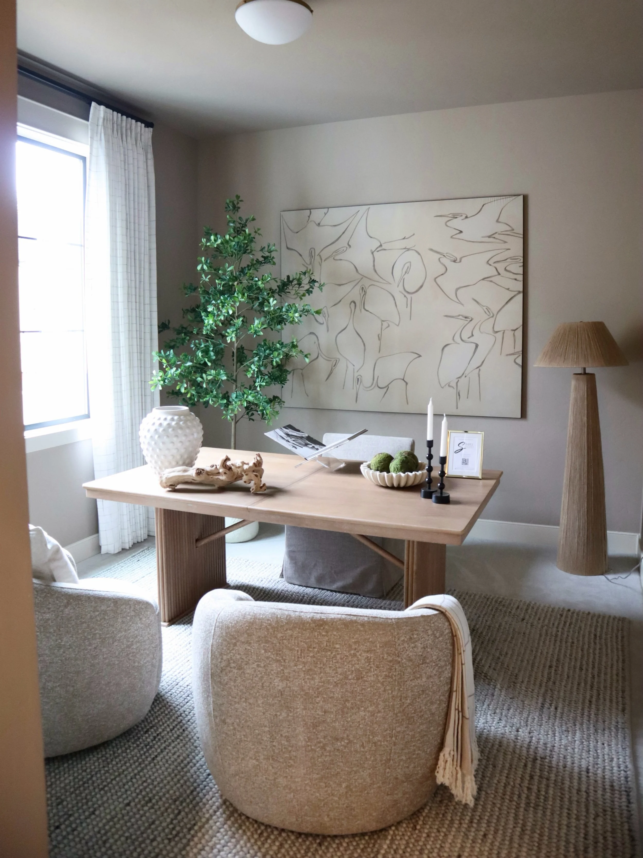 For this office, we layered warm wood tones with soft boucle, oversized organic artwork, sculptural greenery and just enough contrast in the smaller styling pieces.

Even the desk was intentionally styled, natural wood, collected objects, black candl