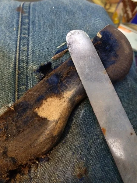 scraping off the old fabric from wood frame