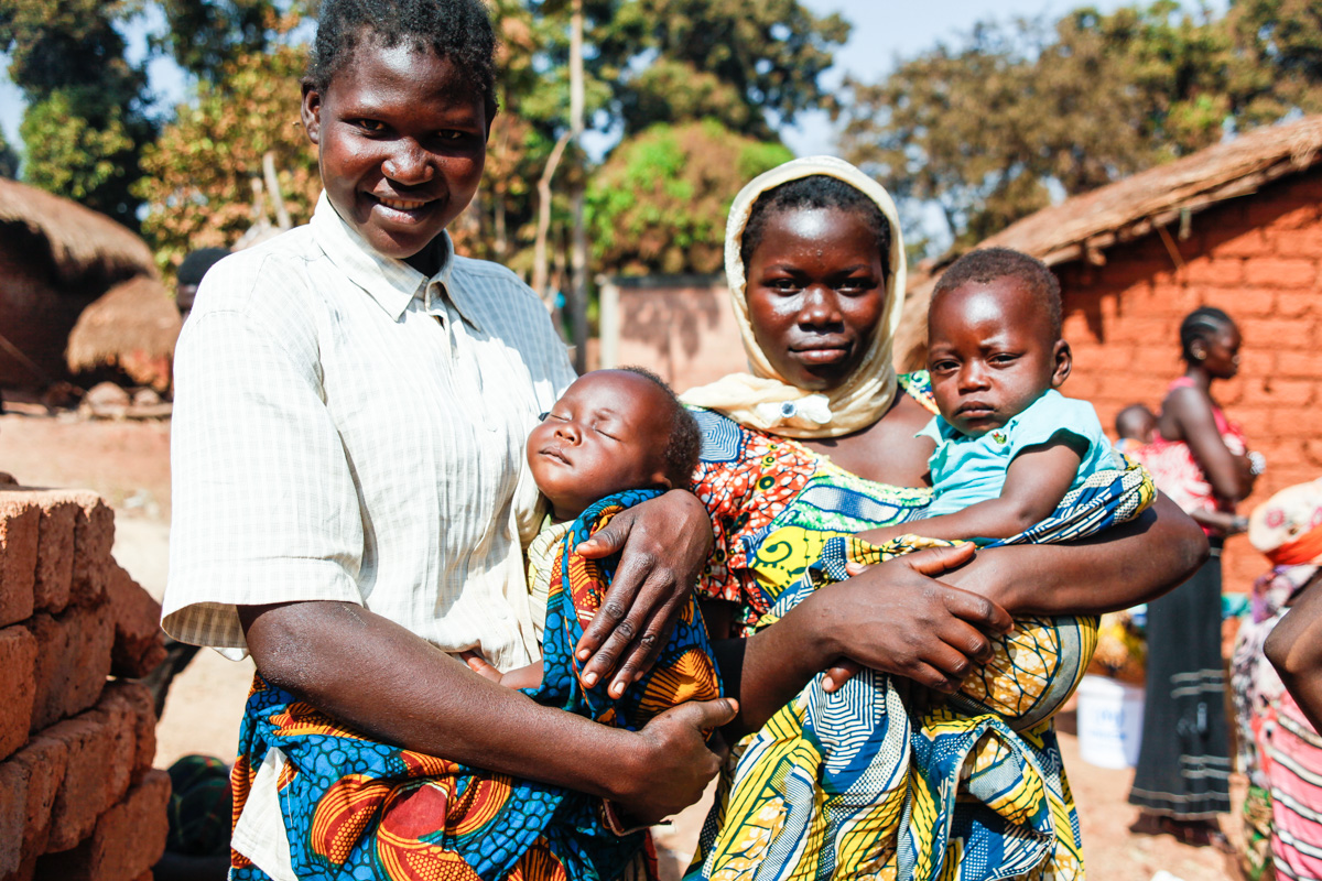 While mothers waited in line for supplies to be distributed by the UN, they volunteered to have their photos taken. They each had their children tied to their backs but then untied them and brought them around front for the photo.