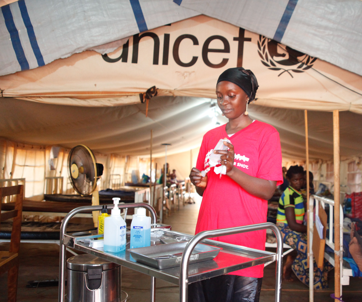  Assistant Nurse, Katidja, prepares medication for a patient inside the hospitalization tent.&nbsp; 