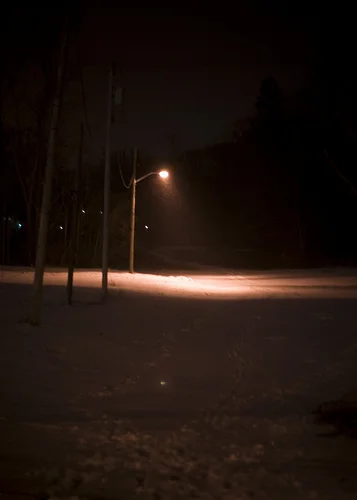 Ypsi Project : Street Light Off Michigan Ave. (via ericarhiannon )
This may seem to be a boring photograph of a street light, but it is not. This street light and I have a history. It sits in an empty lot off Michigan Ave. If you follow the path that you see it will lead you to the Huron River and a mess of burnt abandoned-ness. The light makes for an interesting scene at night- a lonely little street lamp shining in the middle of an empty space. But it likes to play with my emotions and patience. My first few attempts to photograph the light were casual. I noticed it, attempted to take a photograph but it would shut off before I got a chance. The first few attempts were fleeting, casual passings by. Then came the times were I would sit and wait, in the cold, for it to turn back on. I waited and waited some more. Without fail it would turn on as soon as my camera wasn’t paying attention and turn off again when my camera pulled itself together. Tonight I drove passed again and noticed it was on, turned around and drove back and it was off…..I waited in the middle of the street ( because the snow prevented me from driving in and it was far to chilly to park and walk) and snapped this one and another blurry one quickly before it turned off again. Ha! on you light…..*raspberry*