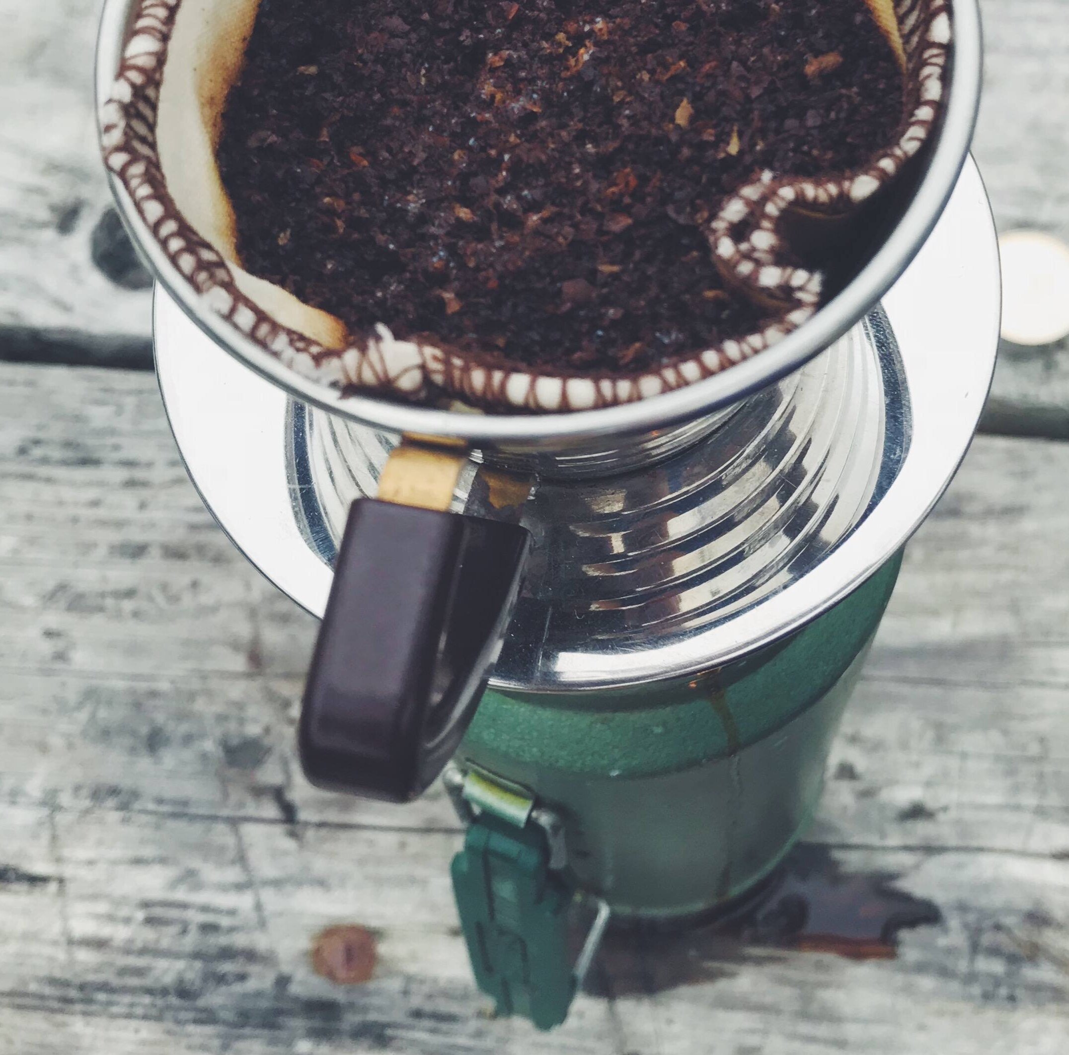 https://images.squarespace-cdn.com/content/v1/56f4a20f86db433fc5a83e2b/1631465914432-ATW2WYR6W4M0SAKGFFVC/coffee+dripper+on+top+of+a+canteen+outdoors