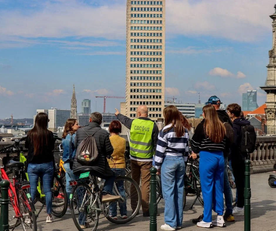 Een groep toeristen bezoekt Brussel met fiets. De gegidste fietstocht met Nederlandstalige gids laat hen de highlights en verborgen parels van Brussel ontdekken.
