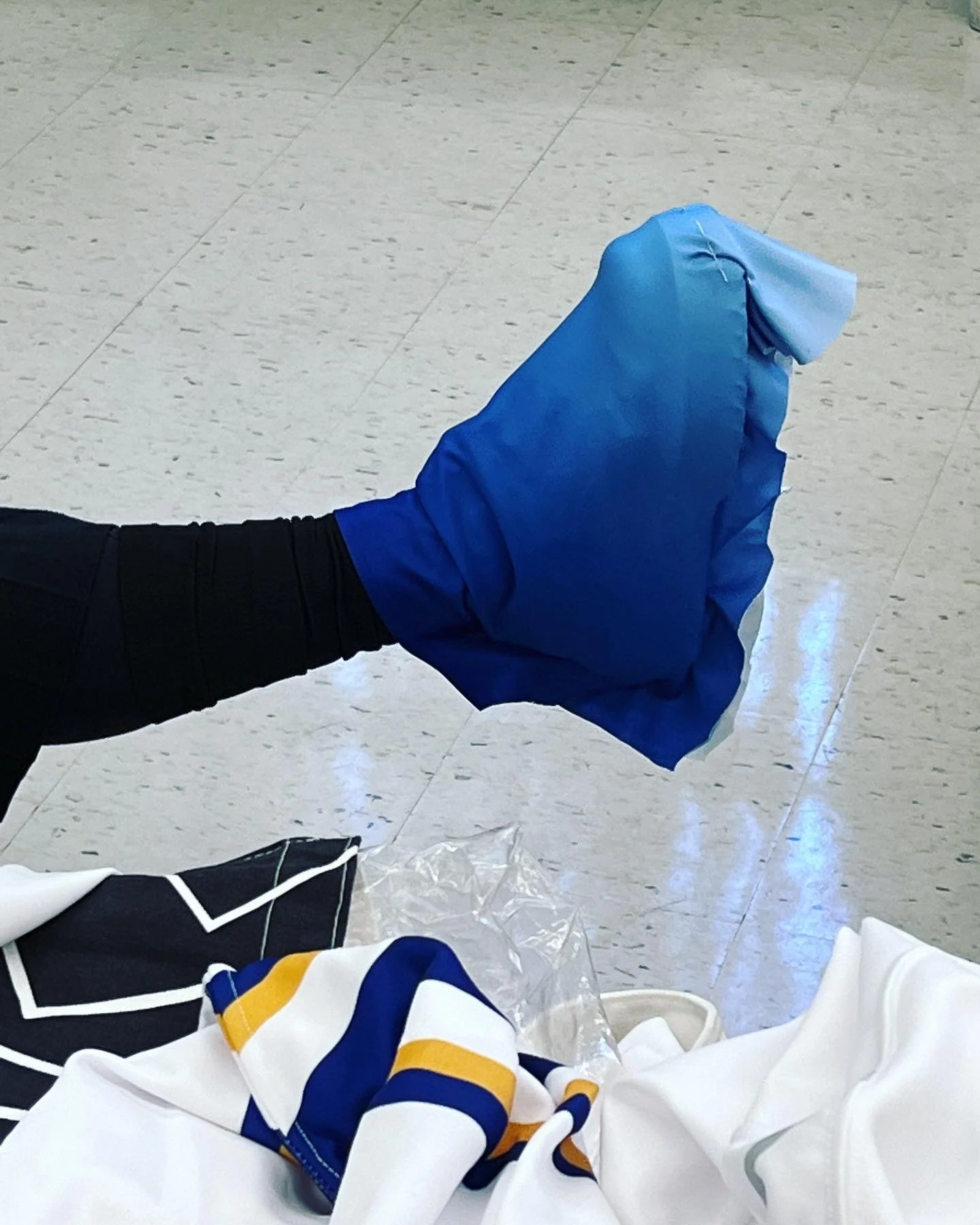 a foot mid-air with blue fabric draped over the shoe