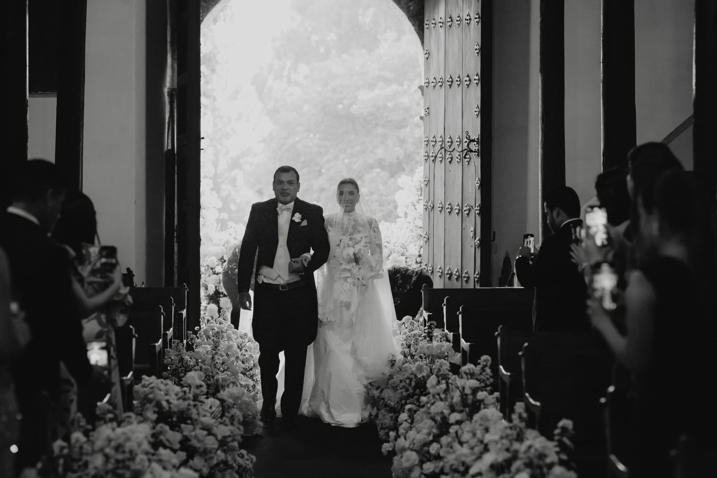 Bride walking down the aisle during a destination wedding ceremony at San Juan del Obispo Church.