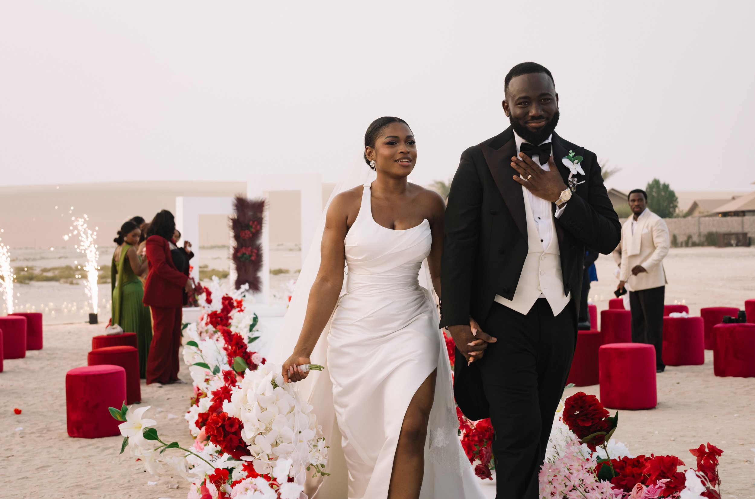 Bride and groom existing the desert ceremony  at The Outpost Al Barari Qatar