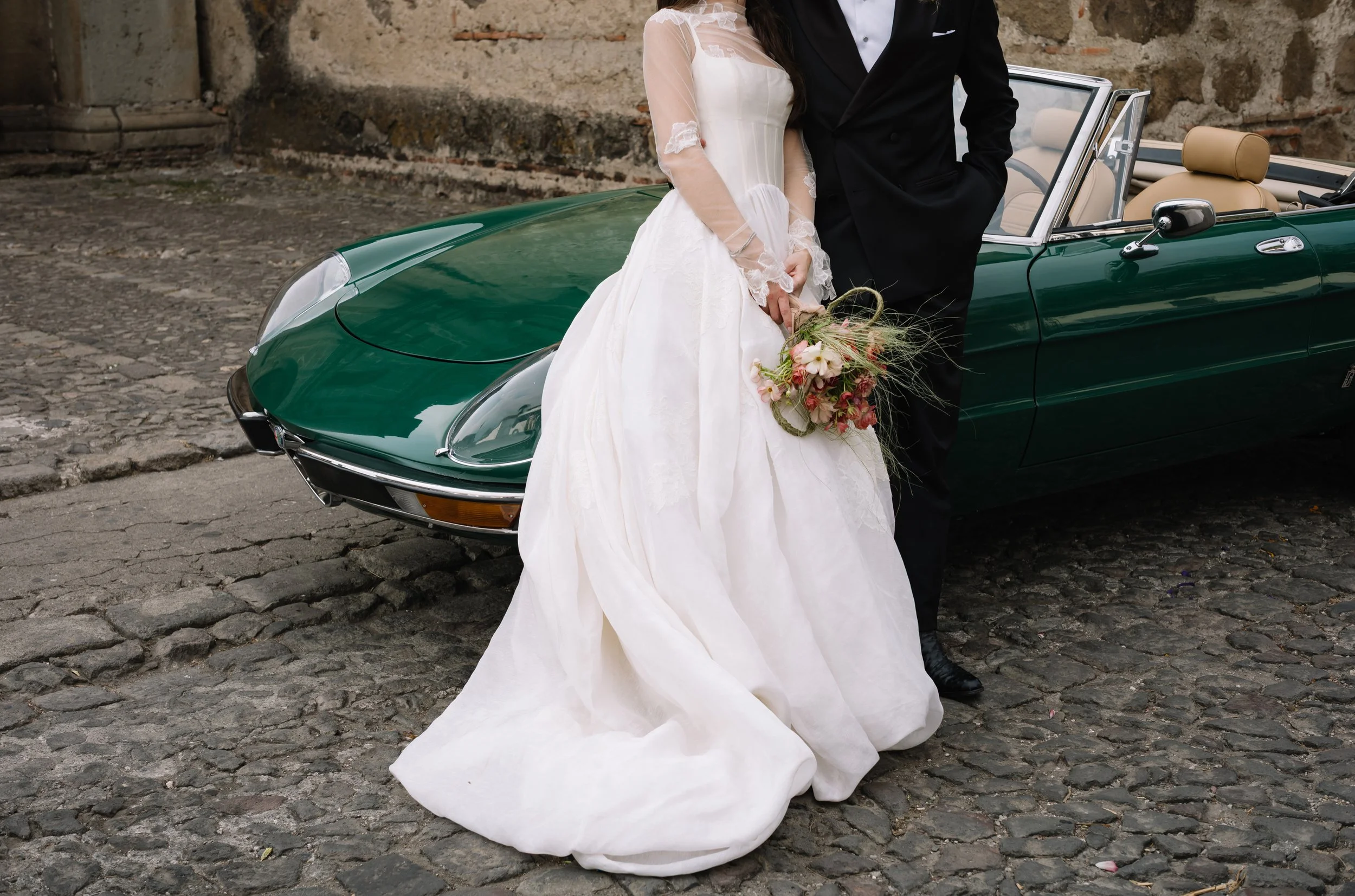 Bride and groom beside a vintage car in Antigua