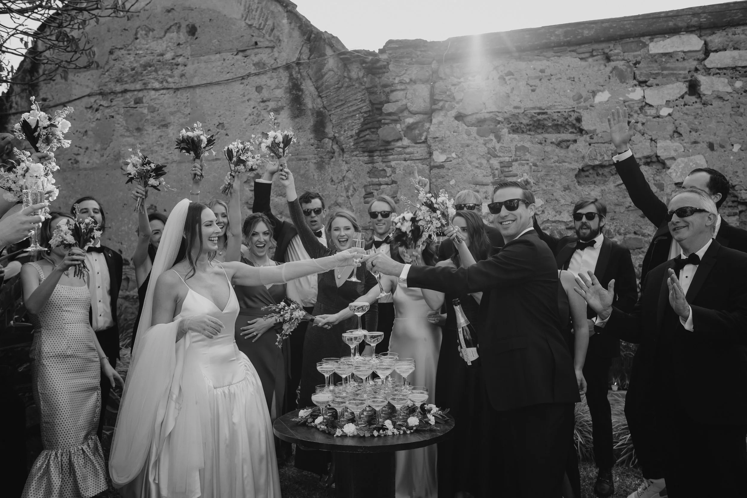 Documentary-style wedding photography of a bride and groom celebrating with guests at Santa Clara Ruins in Antigua Guatemala.