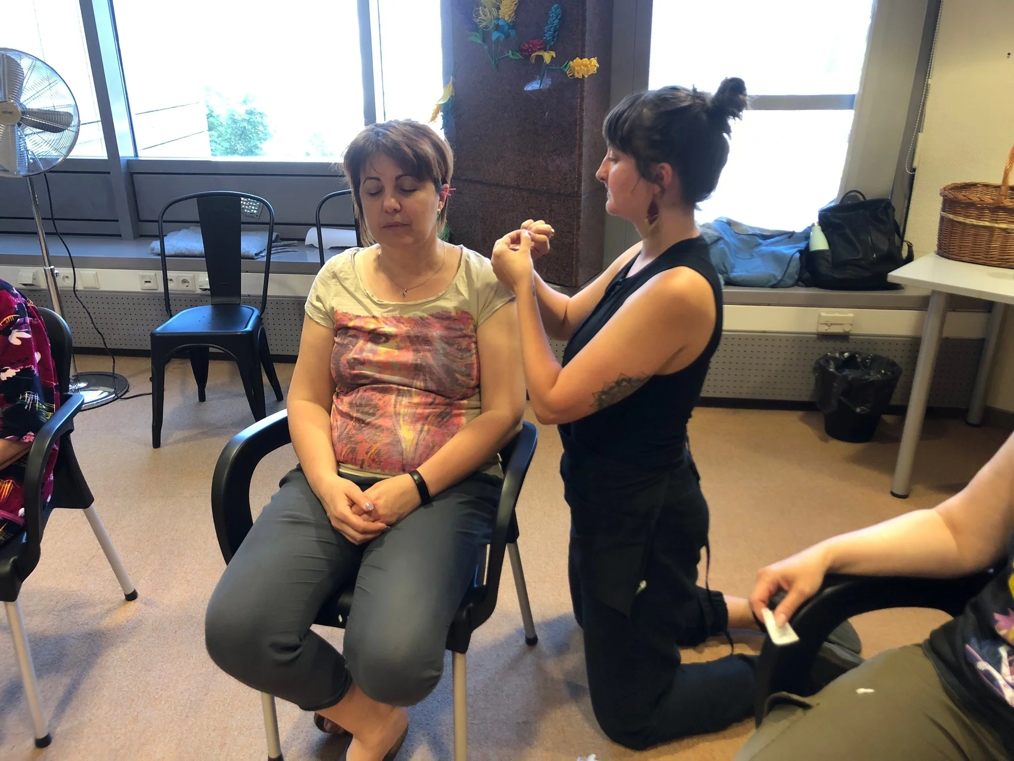 Acupuncturist giving ear acupuncture to patient