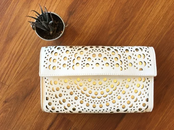 This white peek-a-boo clutch also comes with a gold chain strap. A Sunday brunch or an evening out.