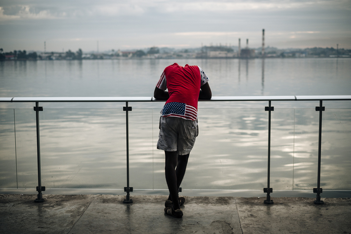  A young boy dressed in a US flag t-shit waits for the boat at the ferry terminal in Havana Vieja. 