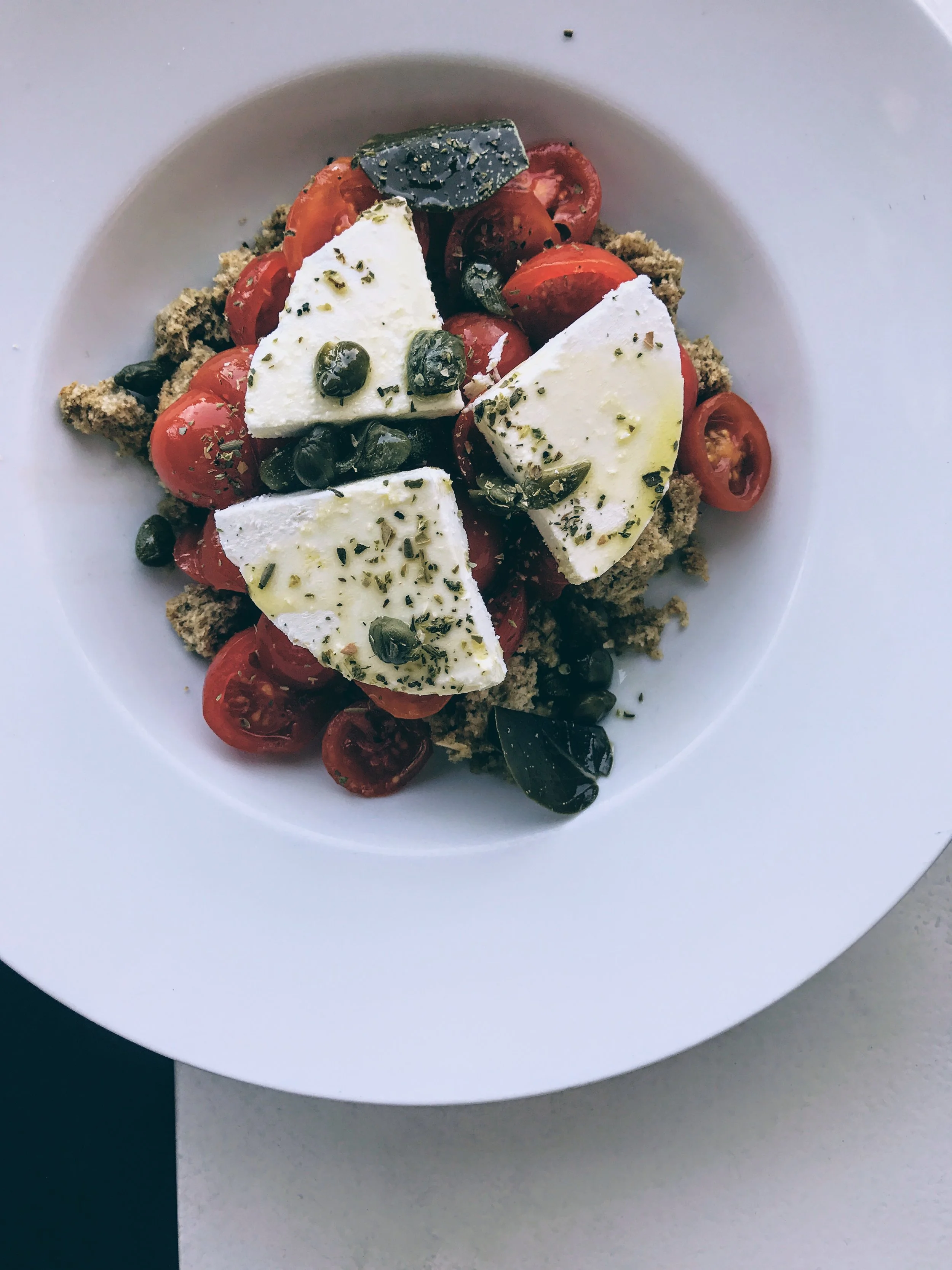 Pomodorini tomato salad with Cretan rusk, caper leaves and Mykonos xinomizithra cheese