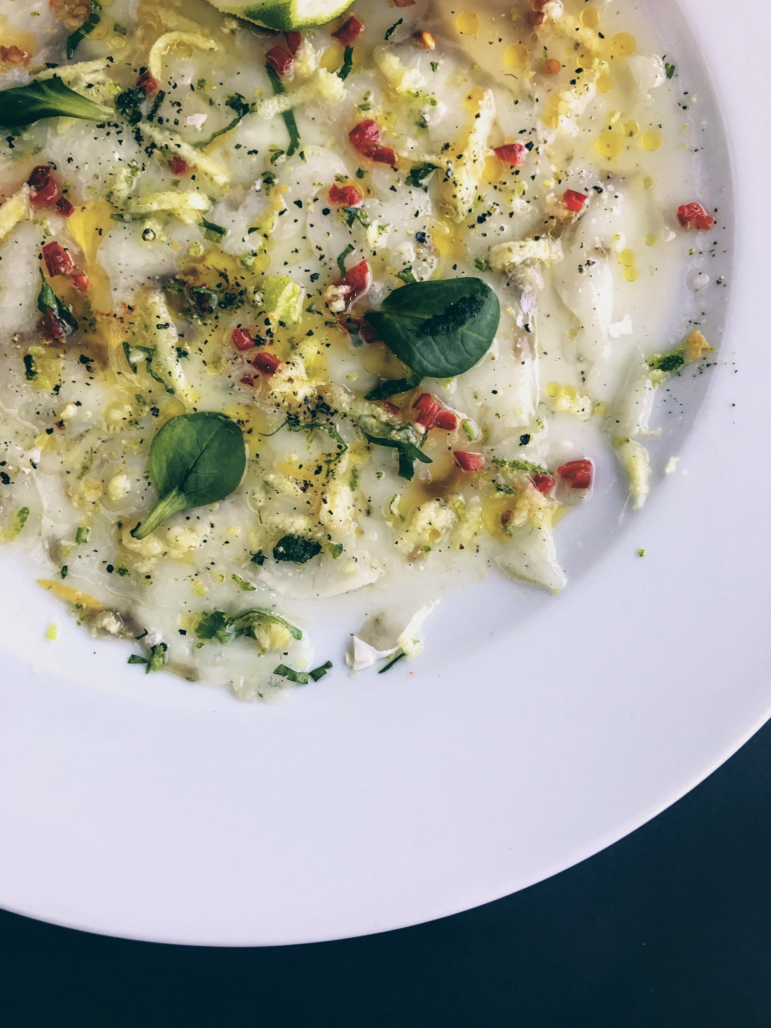 Seabass carpaccio over grapefruit zest, fresh basil and chilli flakes