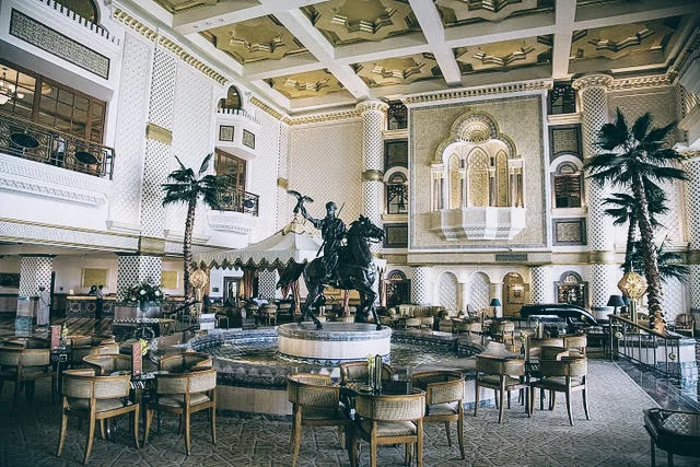 The ornate lobby of the Hyatt, and the outdoor pool area of the Al Bustan Palace / Source: Wikimedia Commons