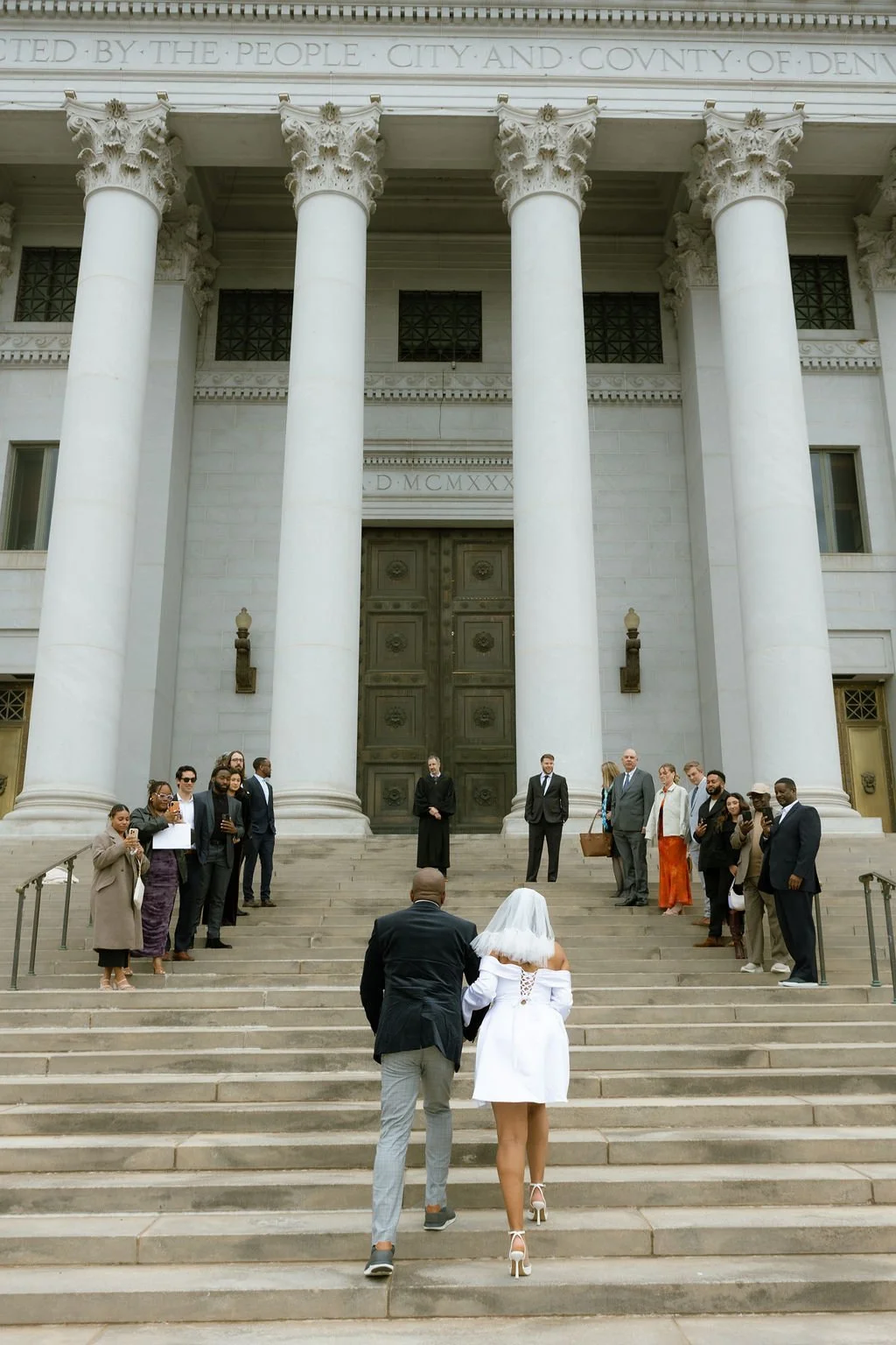 Father walking Bride up the Denver Courthouse steps on her wedding day.