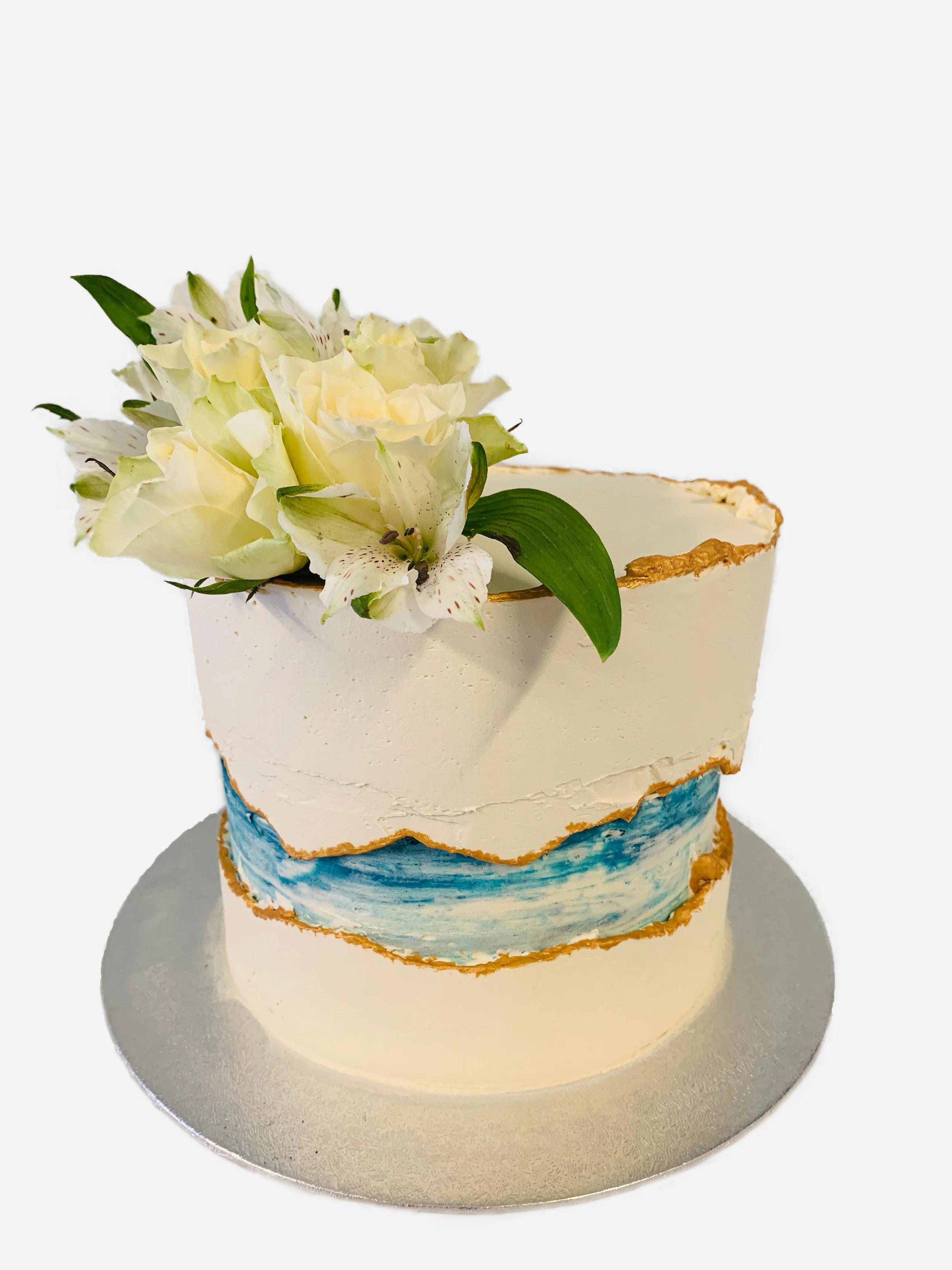 Single tier blue fault line cake with gold accents and fresh flowers