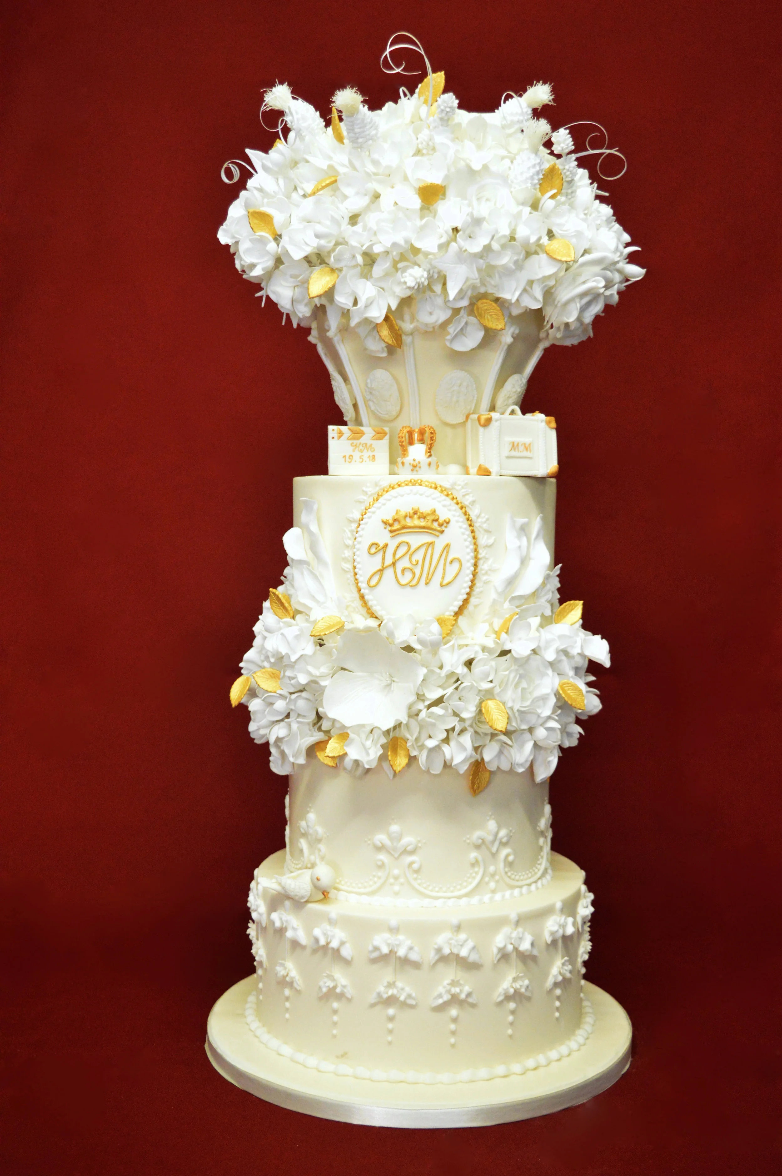 3 tier wedding cake adorned with sugarflowers and royal emblem