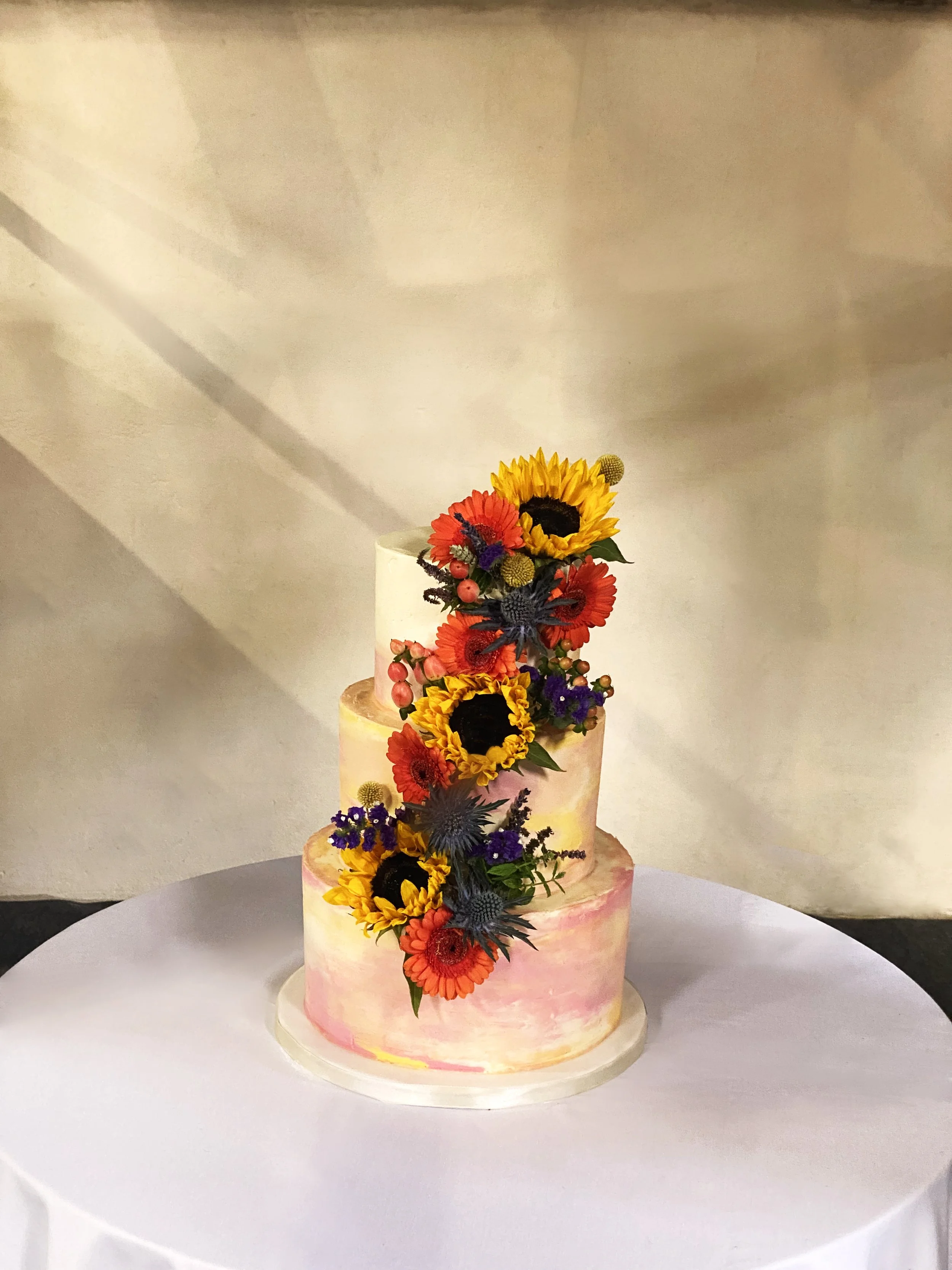 Watercolour effect 3 tier buttercream wedding cake decorated with fresh flowers