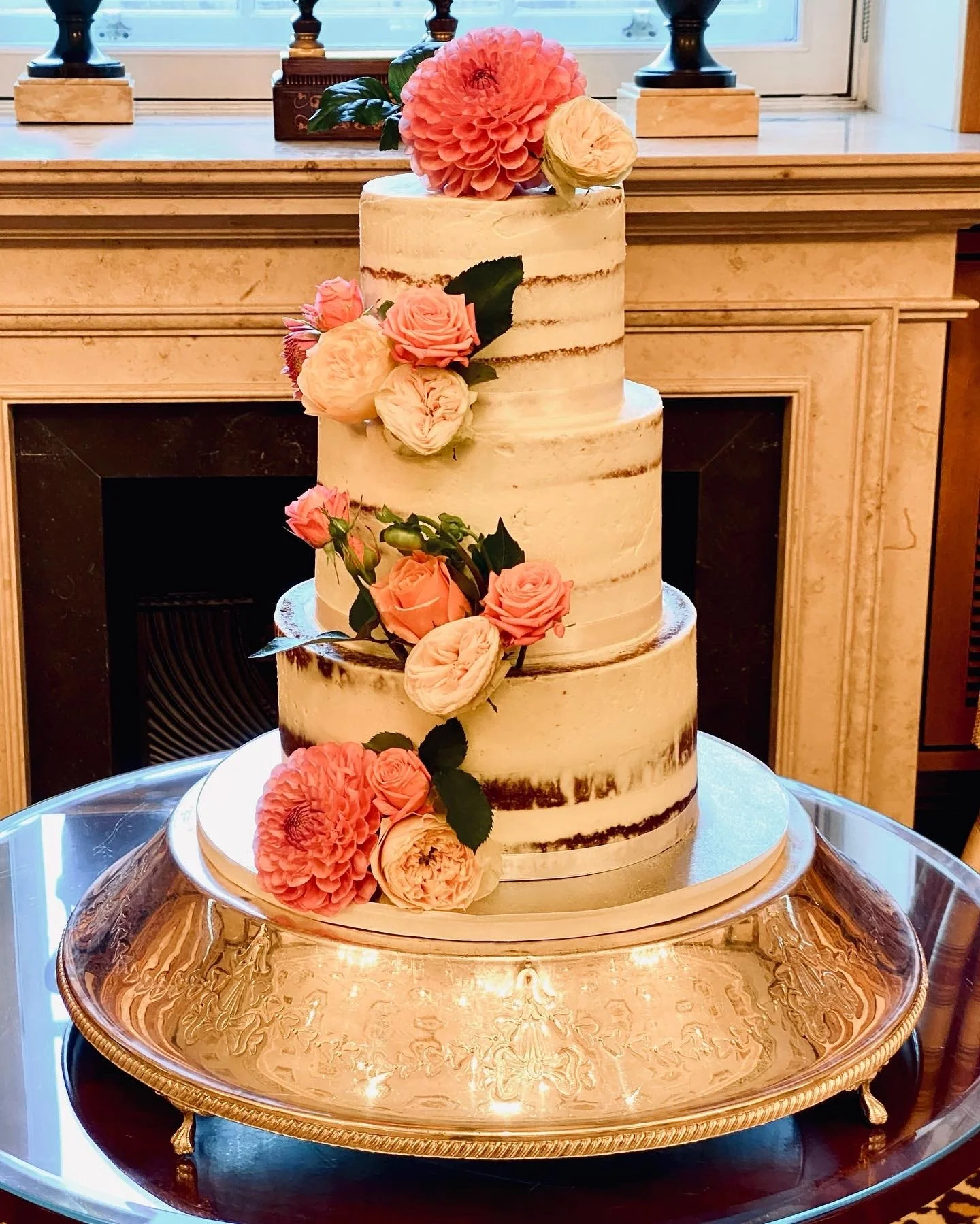 A 3 tier semi naked wedding cake decorated with real flowers
