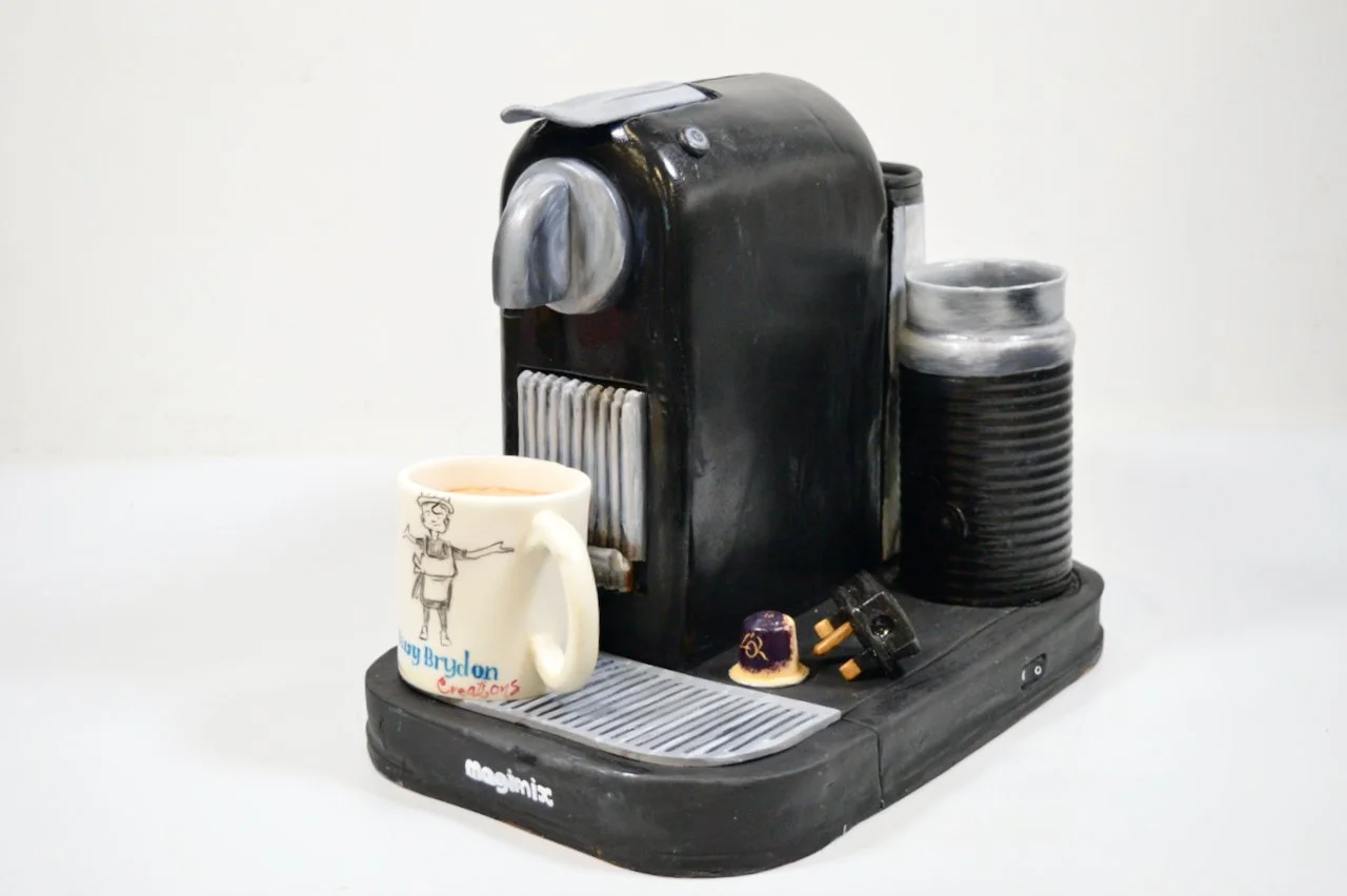 Nespresso coffee machine cake complete with chocolate milk frother, pod and plug. This cake came 3rd in The Ideal Home Show cake competition 2026