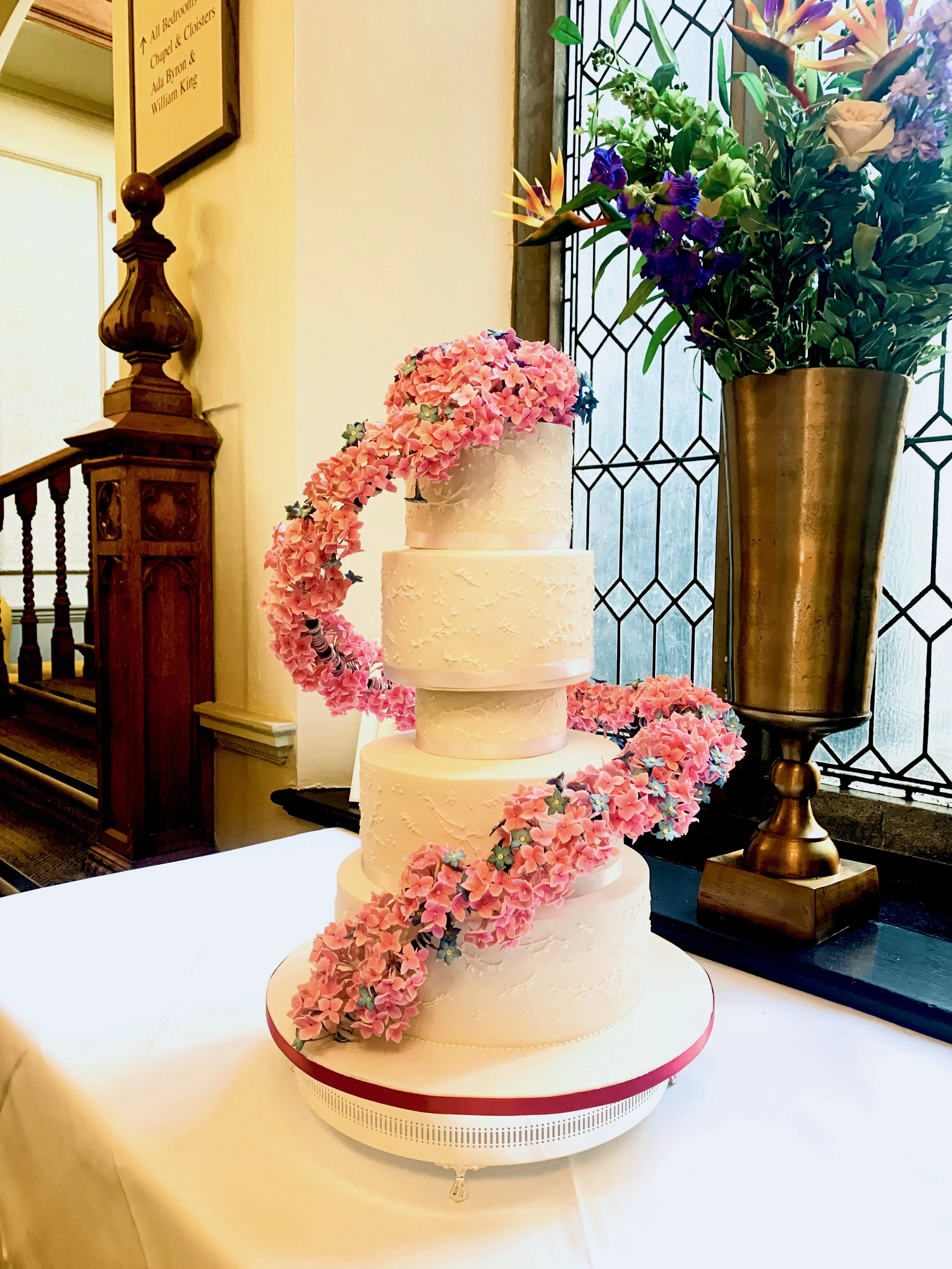 4 tier wedding cake with suspended sugarflower blossoms cascading down the cake