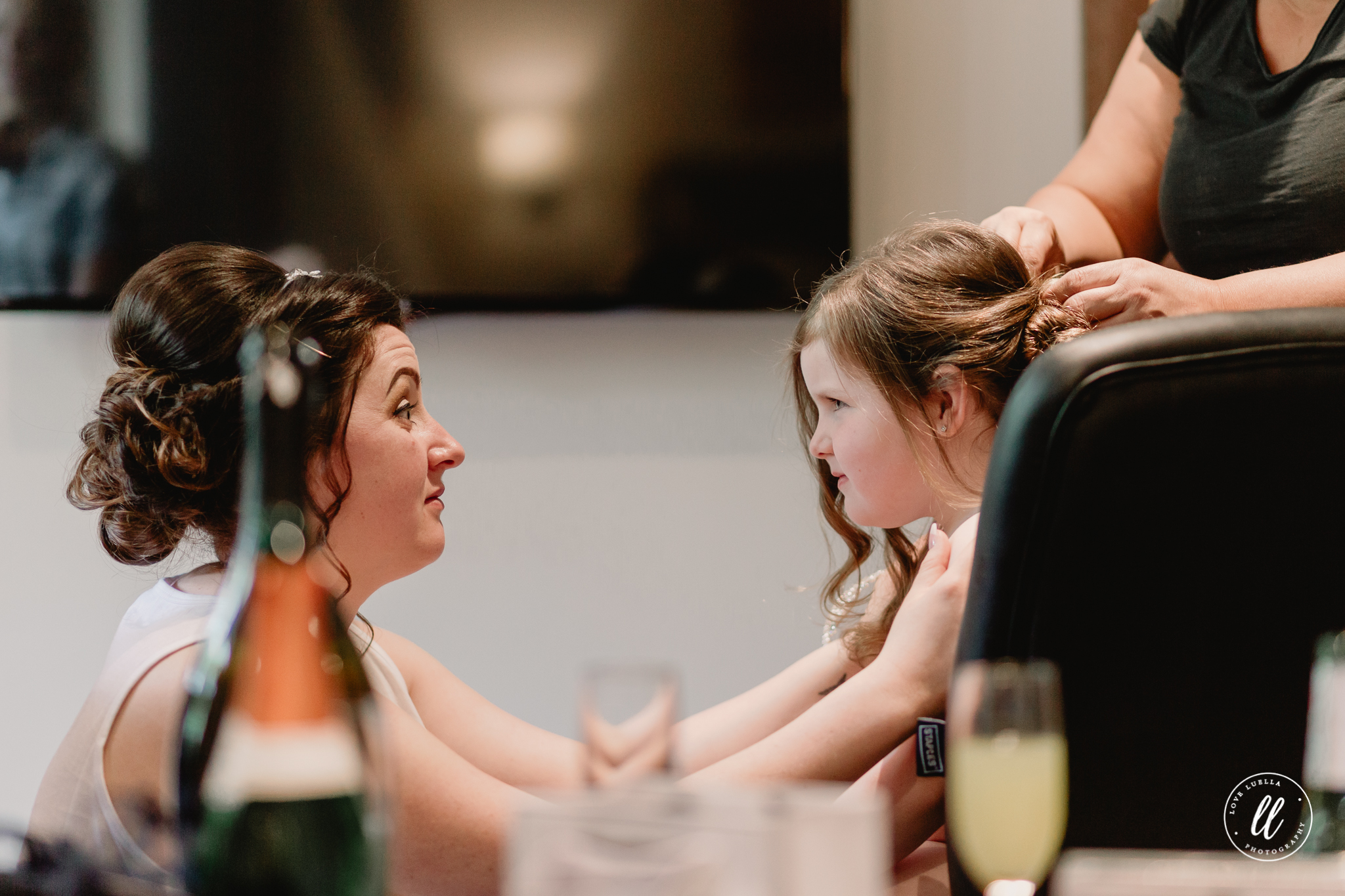 The bride giving her daughter/flower girl some cheering on through the boring task of getting her hair done up.
