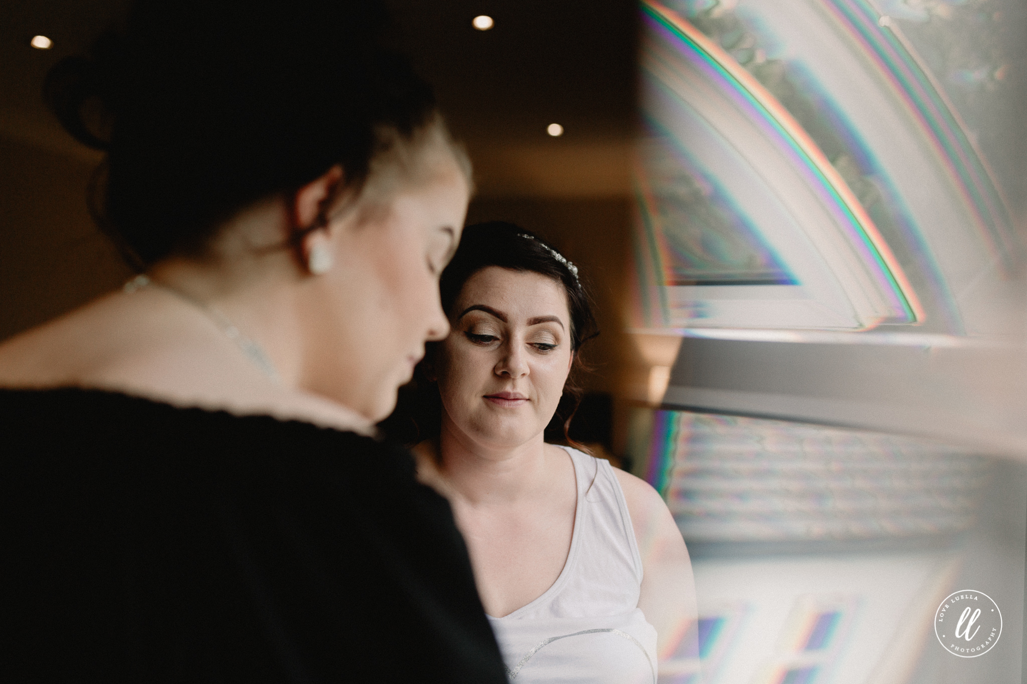 A candid image of the bride using a prism effect at the window