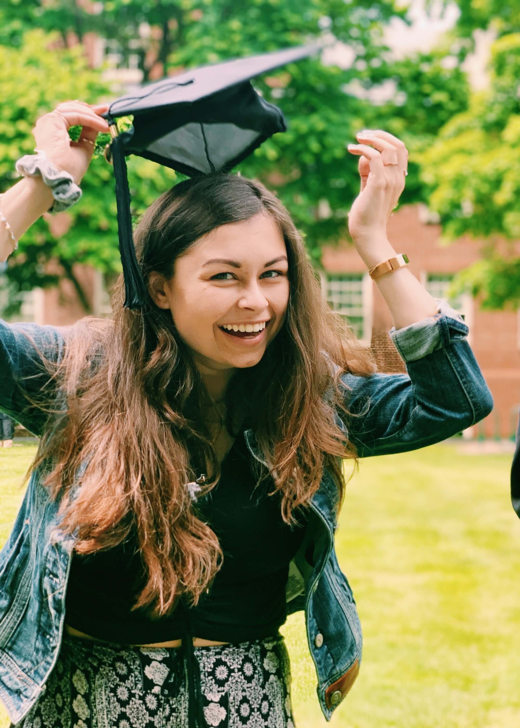 Grace placing a graduation cap on her head.