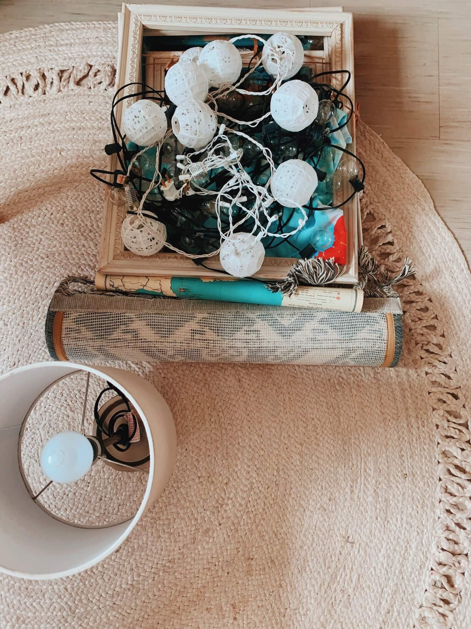 Lights, picture frames, and a moving box sit on a carpet.