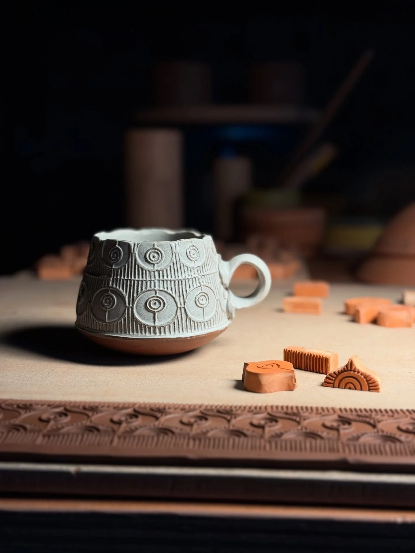 It’s a rainy/snowy day outside, and I’m settled into the cozy studio for a day of mug-making. I’m stamping clay while testing out a new glaze variant on a fresh-outta-the-kiln mug. It’s a rigorous (and strenuous) R&D sched