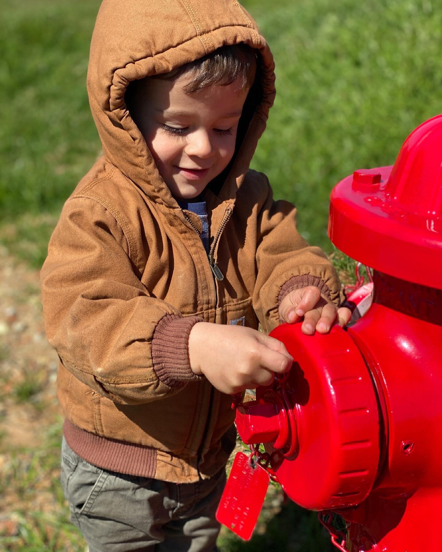 Just a boy, a shiny new fire hydrant, and a tractor.