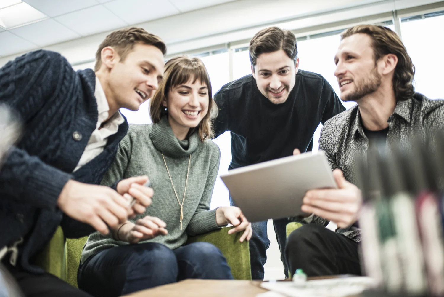 stock-photo-four-people-colleagues-at-a-meeting-and-one-man-sharing-a-tablet-with-the-group-110988001.jpg