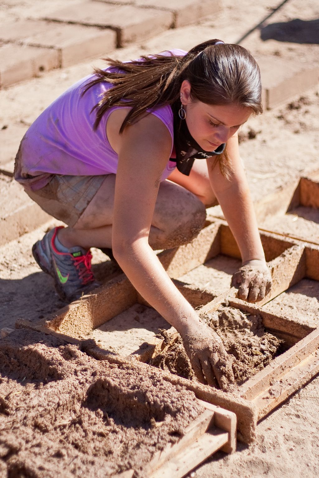 Volunteer filling an adobe block form.