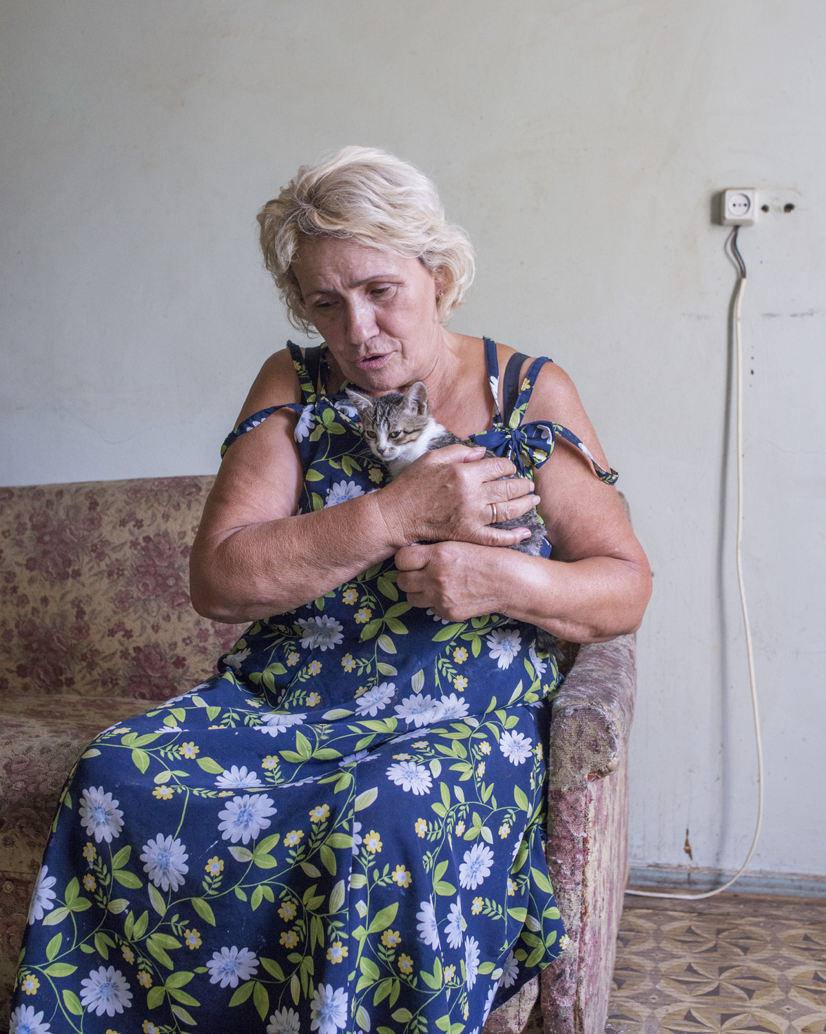Marie, 70, lives in the government-assisted shelter Collective Center in the city of Mariupol after fleeing shelling in the east. "This kitten is named Mariska. She heals me by taking away bad energy."