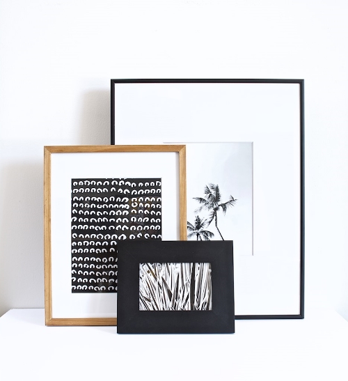 Our black and white prints stacked on a shelf